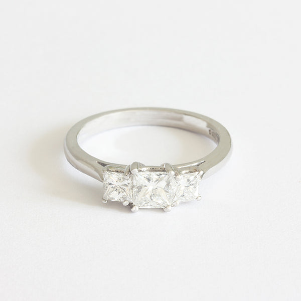 a 3 stone diamond engagement ring with 3 princess cut diamonds and set in platinum