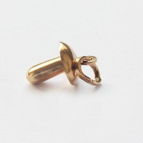 a yellow gold baby dummy charm