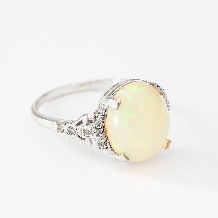 oval opal and diamond claw set ring set in 18ct white gold