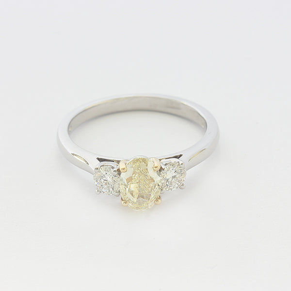 a platinum diamond 3 stone ring with central yellow diamond