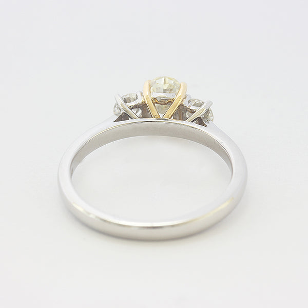 a platinum 3 stone ring with central oval yellow diamond